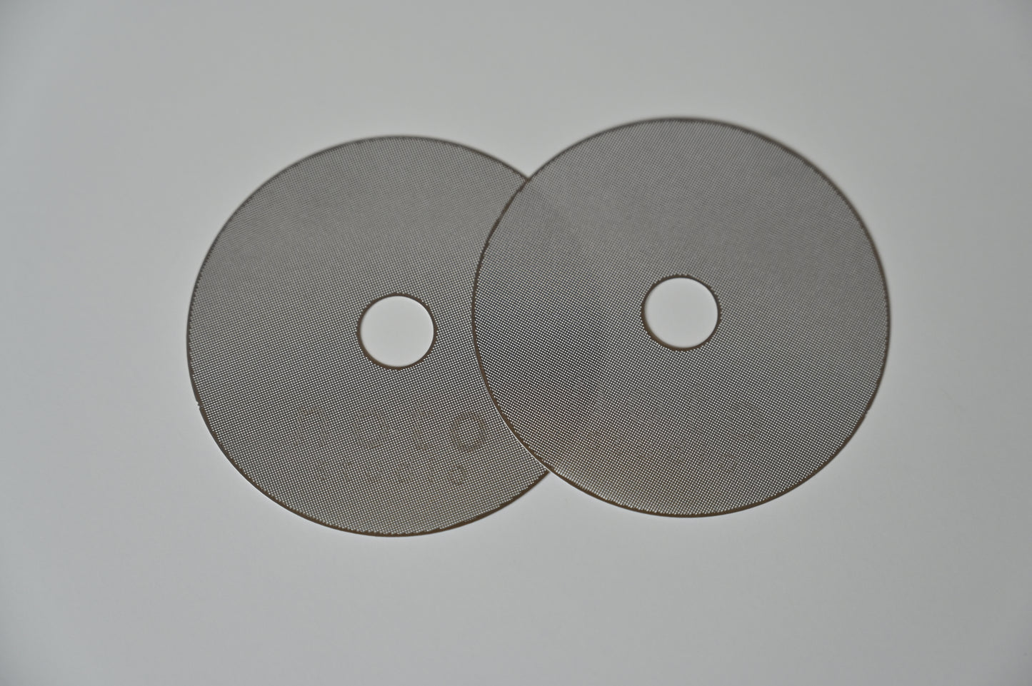 Two noto studio stainless steel puck screens showing the fine 200-micron perforated mesh